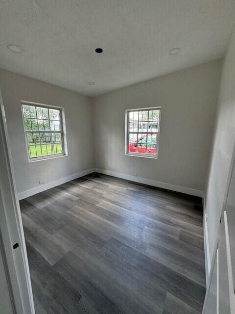 unfurnished room with a textured ceiling and hardwood / wood-style floors