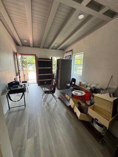 misc room with hardwood / wood-style flooring and vaulted ceiling with beams