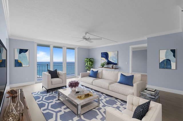 living room with light hardwood / wood-style flooring, a textured ceiling, ceiling fan, a water view, and crown molding