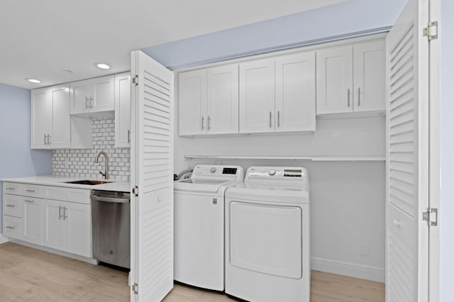 laundry area with sink, separate washer and dryer, and light hardwood / wood-style floors