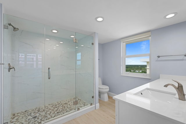 bathroom with an enclosed shower, vanity, toilet, and hardwood / wood-style floors