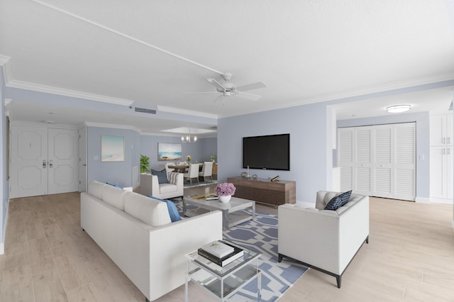 living area featuring light wood-style floors, visible vents, crown molding, and ceiling fan with notable chandelier