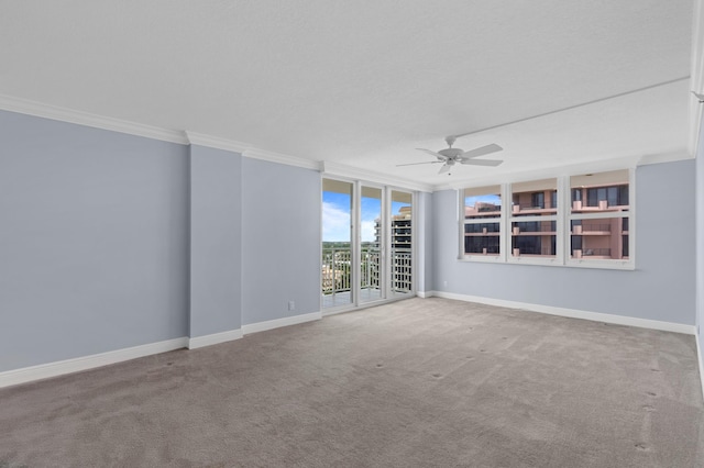 carpeted spare room featuring floor to ceiling windows, crown molding, and ceiling fan