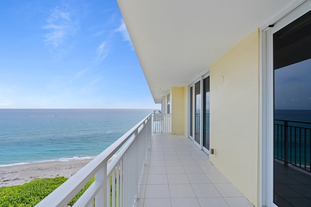 balcony featuring a water view and a beach view