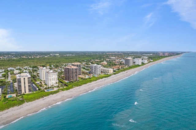 drone / aerial view with a water view, a view of the beach, and a city view