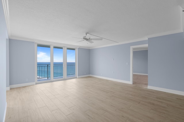 spare room featuring ornamental molding, light wood finished floors, and a water view