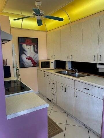 kitchen with sink, white cabinetry, light tile patterned floors, and ceiling fan