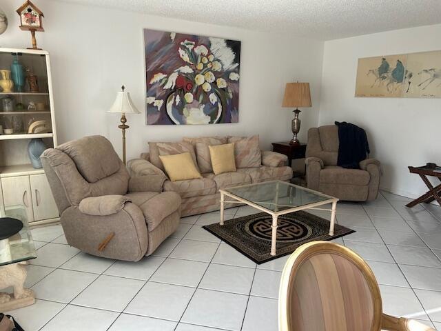 living room featuring a textured ceiling and light tile patterned floors