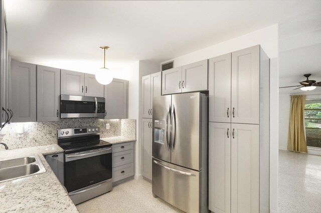 kitchen with appliances with stainless steel finishes, sink, gray cabinets, decorative backsplash, and ceiling fan