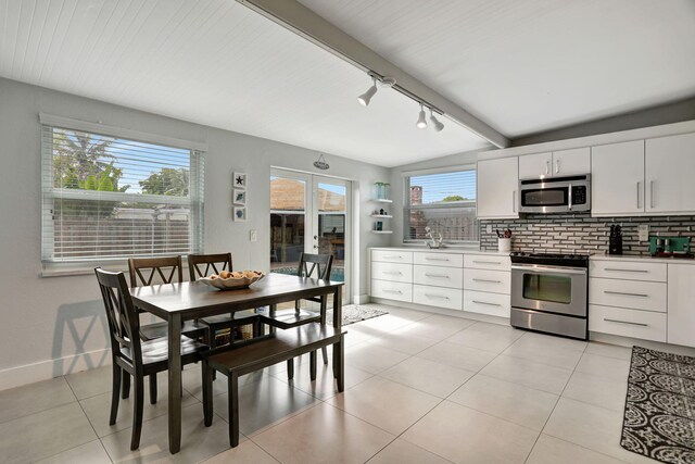 5278 NE 19th Ter, Pompano Beach, FL 33064 - kitchen with appliances with stainless steel finishes, rail lighting, backsplash, light tile patterned flooring, and white cabinetry