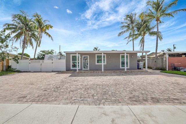 5278 NE 19th Ter, Pompano Beach, FL 33064 - view of front of home with a gate, stucco siding, and driveway