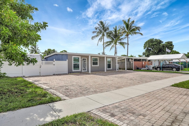 5278 NE 19th Ter, Pompano Beach, FL 33064 - view of front of property with a gate, stucco siding, a carport, and driveway