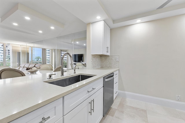 kitchen featuring a sink, white cabinetry, light countertops, dishwasher, and tasteful backsplash