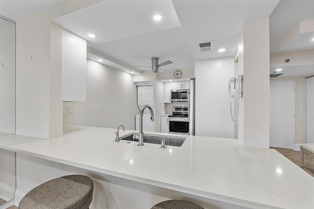 kitchen featuring ceiling fan, hardwood / wood-style floors, sink, range with electric cooktop, and kitchen peninsula