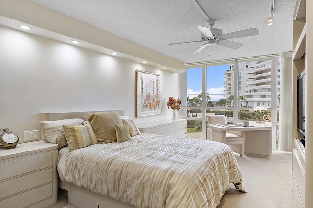 bedroom featuring recessed lighting, light colored carpet, expansive windows, ceiling fan, and a textured ceiling