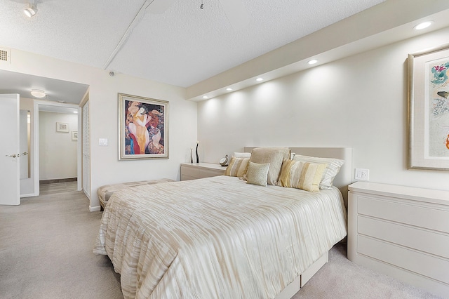 bedroom featuring a textured ceiling, recessed lighting, visible vents, and light colored carpet