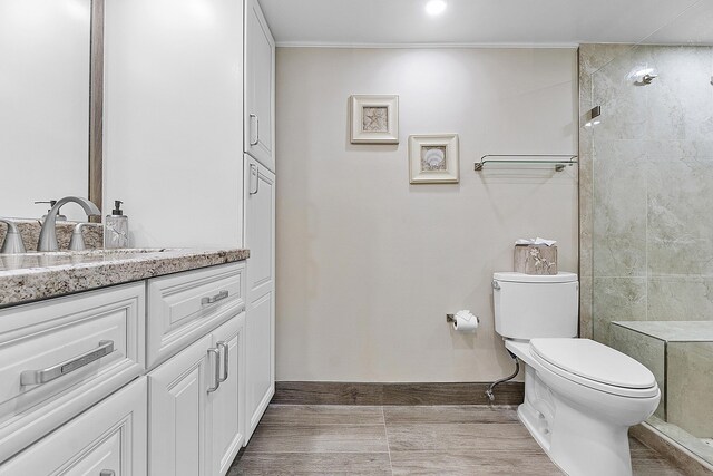 bathroom with tiled shower, vanity, tile patterned floors, and toilet