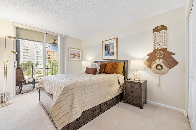 carpeted bedroom with access to exterior and a textured ceiling