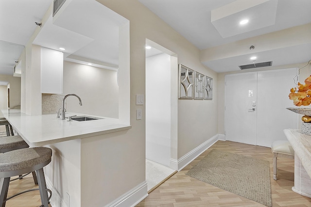 interior space with light wood finished floors, recessed lighting, visible vents, and baseboards