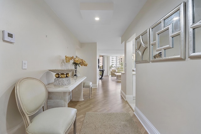 corridor with baseboards, recessed lighting, and light wood-style floors