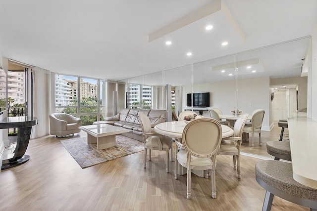 living area featuring a wall of windows, recessed lighting, and light wood-style floors