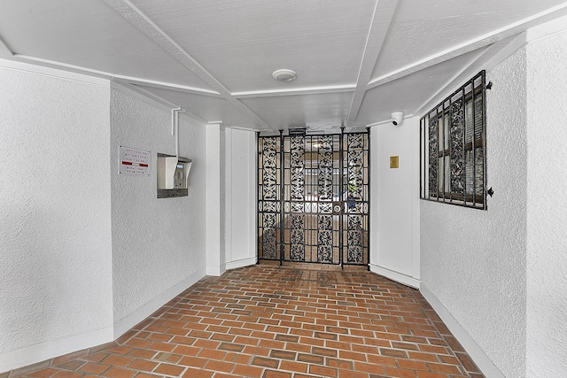 interior space with a textured wall and brick floor