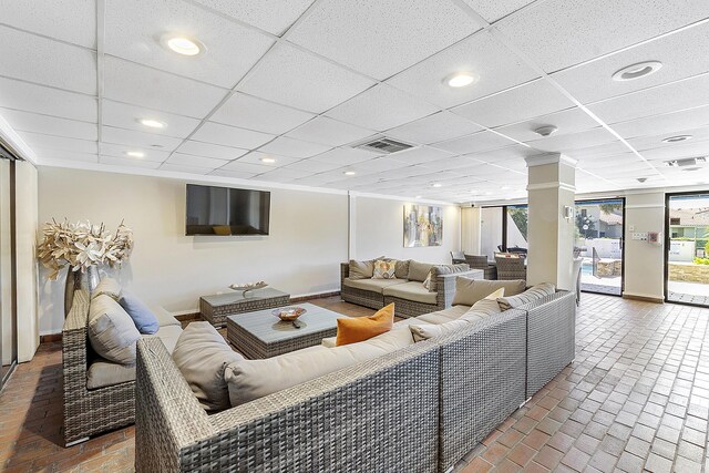 living room with a paneled ceiling, brick floor, visible vents, and recessed lighting