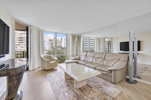 living room with expansive windows, light wood finished floors, and baseboards