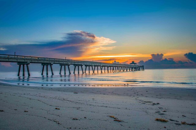 dock area featuring a beach view, a water view, and a pier