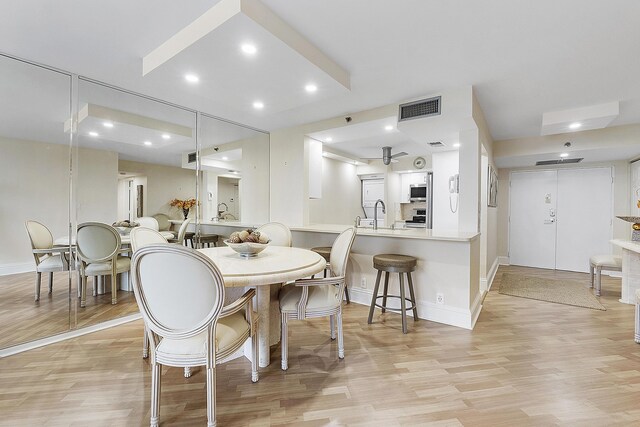 dining area with baseboards, light wood-type flooring, visible vents, and recessed lighting