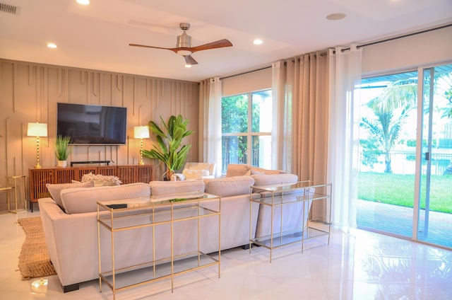 living room featuring ceiling fan and wood walls