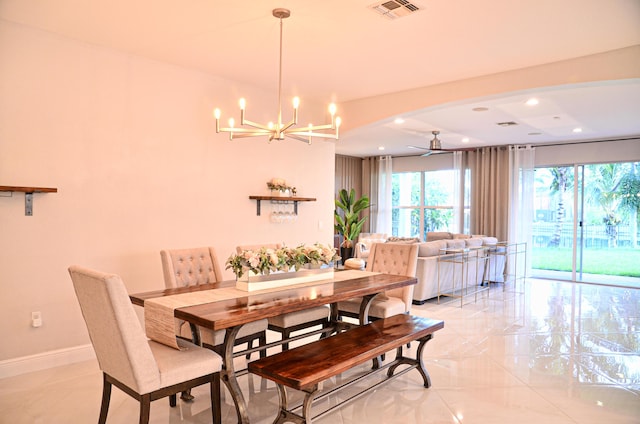 dining area featuring ceiling fan with notable chandelier