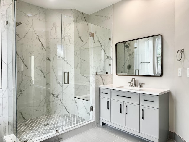 bathroom featuring a shower with door and vanity