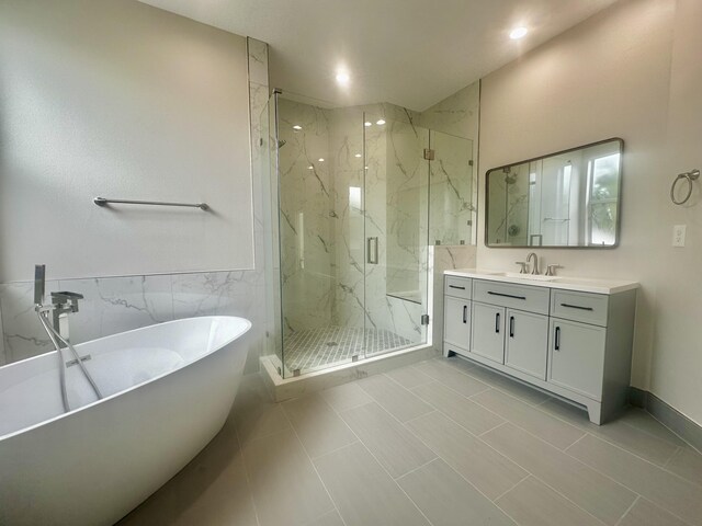 bathroom featuring tile walls, independent shower and bath, tile patterned floors, and vanity