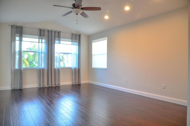 empty room with ceiling fan, dark hardwood / wood-style flooring, vaulted ceiling, and a wealth of natural light