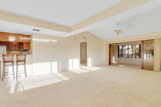 unfurnished living room featuring lofted ceiling, light colored carpet, and ceiling fan