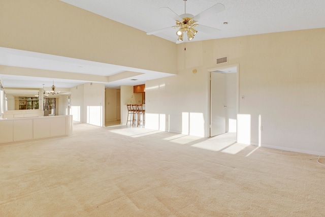 empty room with a high ceiling, light carpet, and ceiling fan