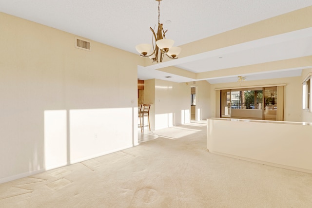 carpeted empty room with a chandelier