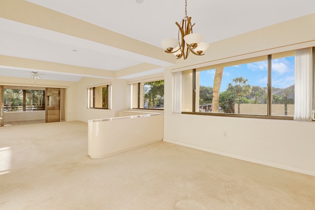 carpeted spare room featuring a notable chandelier and a wealth of natural light