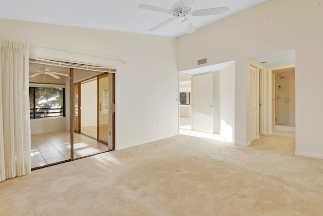 unfurnished bedroom featuring ensuite bath, ceiling fan, lofted ceiling, and light colored carpet