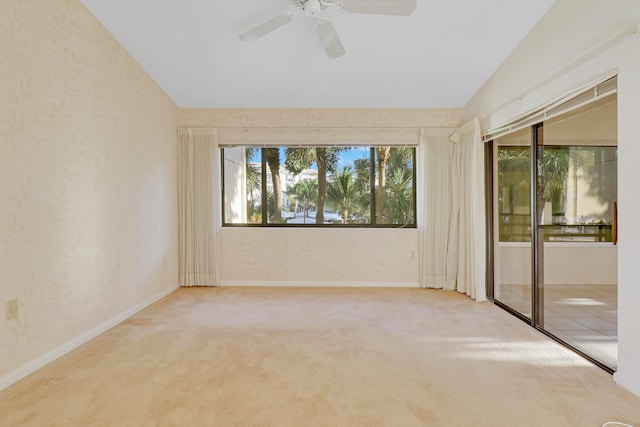 empty room featuring vaulted ceiling, carpet, and ceiling fan