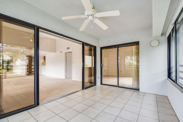 unfurnished bedroom featuring a textured ceiling, light tile patterned floors, and ceiling fan