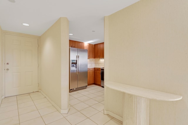 kitchen featuring tasteful backsplash, appliances with stainless steel finishes, and light tile patterned floors