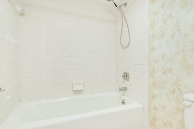 bathroom featuring tiled shower / bath and toilet