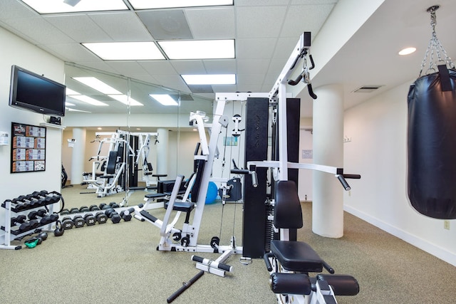 workout area featuring carpet floors and a paneled ceiling