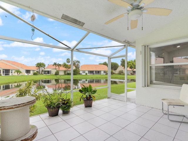 sunroom featuring a water view and ceiling fan