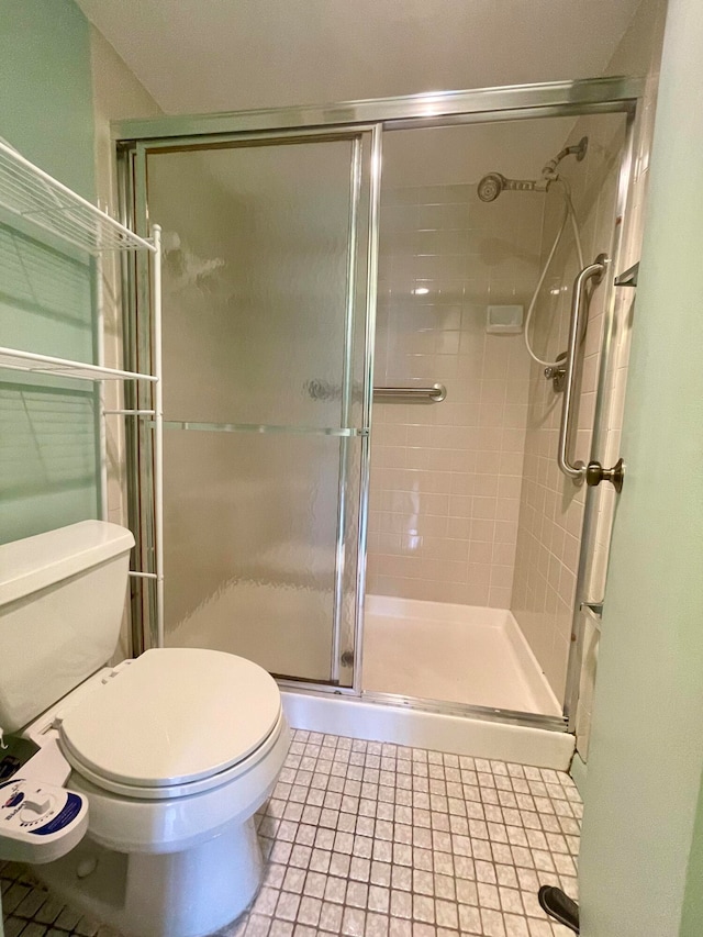 bathroom featuring toilet, tile patterned flooring, and walk in shower