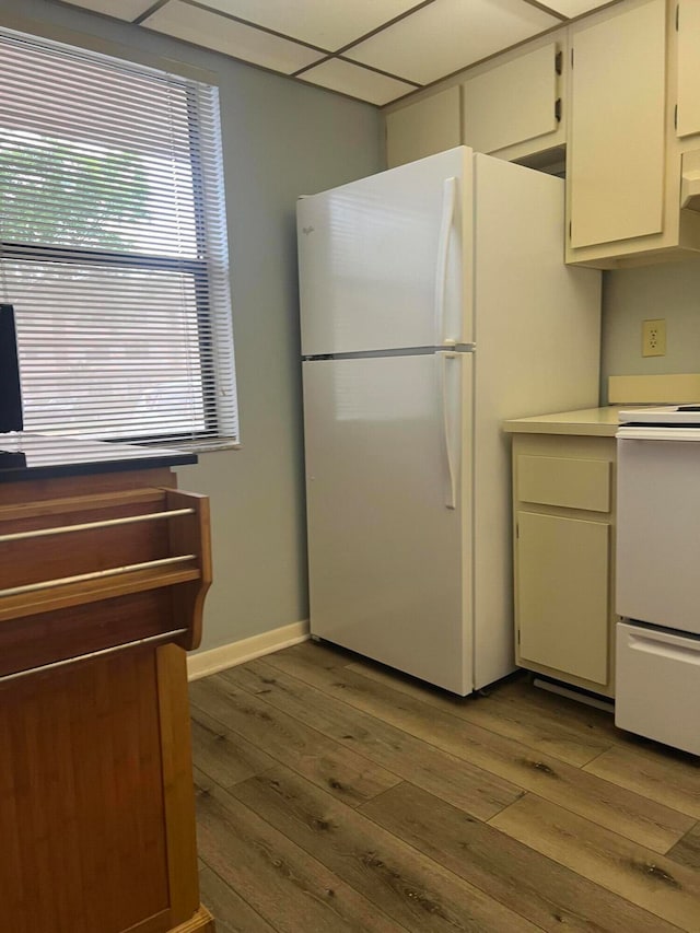 kitchen featuring range, wood-type flooring, white refrigerator, and white cabinets