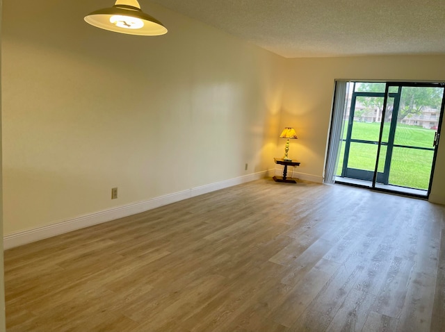 spare room featuring hardwood / wood-style flooring and a textured ceiling