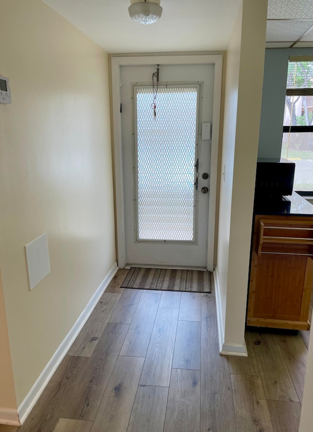 doorway to outside featuring a drop ceiling and hardwood / wood-style floors